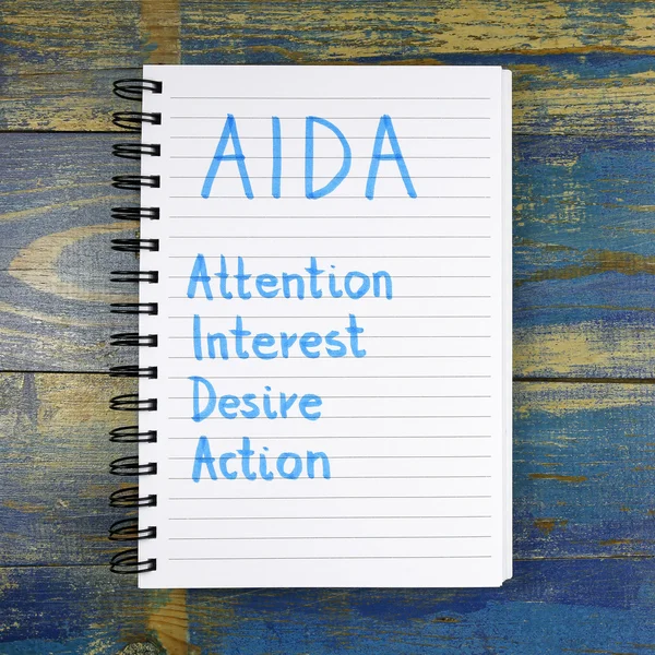 AIDA- Atención Interés Deseo Acrónimo de acción escrito en cuaderno sobre fondo de madera —  Fotos de Stock
