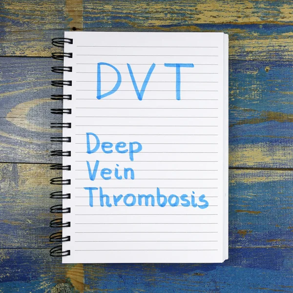 DVT Acronimo di trombosi venosa profonda scritto in notebook su sfondo di legno — Foto Stock