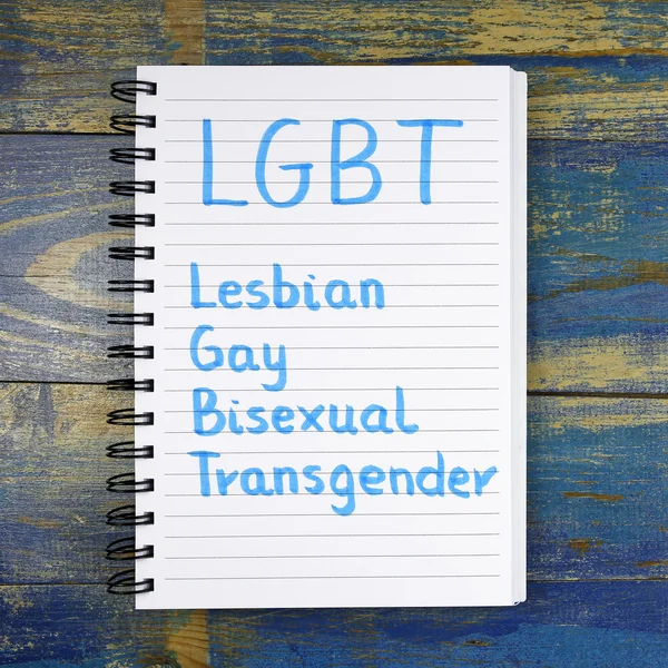 ЛГБТ - лесбіянок, геїв, бісексуалів, транссексуалів акронім написано в блокноті дерев'яними тлі — стокове фото