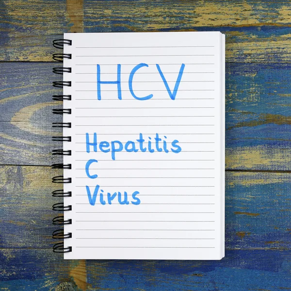 HCV - Hepatitis C-virus geschreven in notebook op houten achtergrond — Stockfoto
