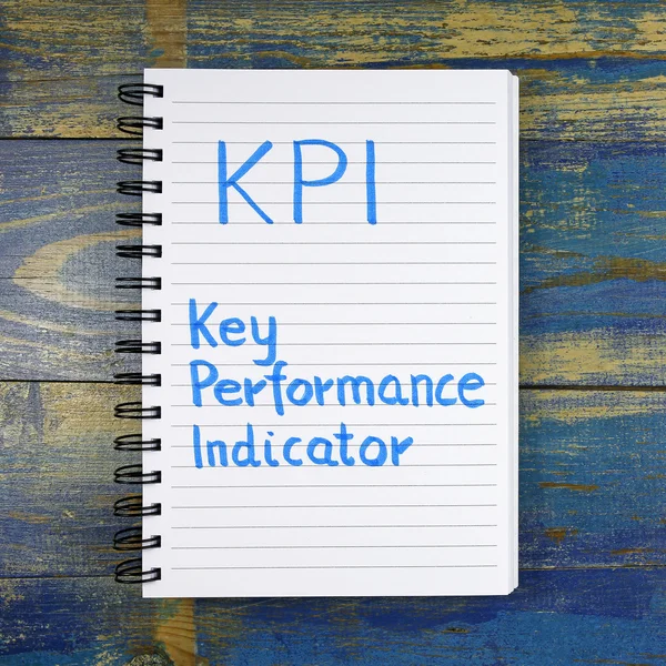 KPI- Key Performance Indicator written in notebook on wooden background