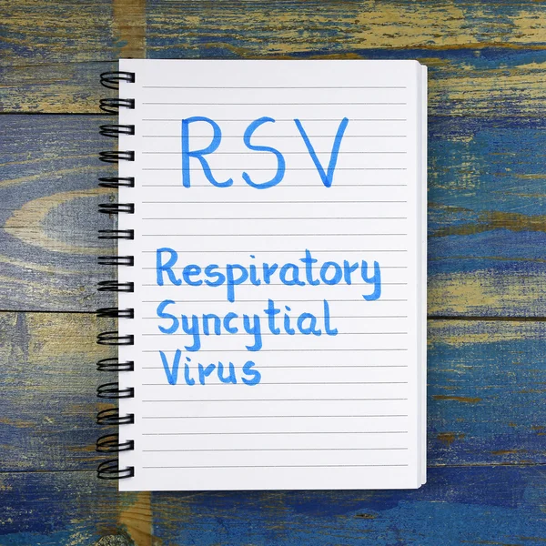 RSV-Respiratory Syncytial Virus acronimo scritto in notebook su sfondo di legno — Foto Stock