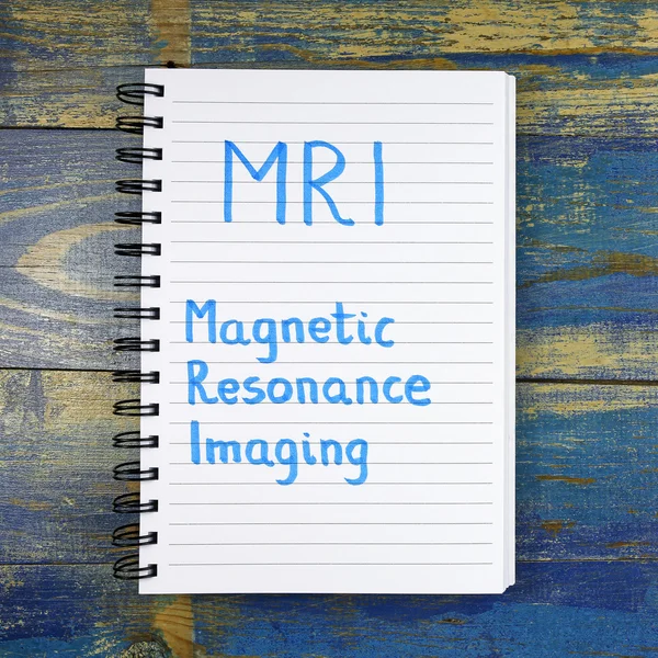 MRI - Magnetic Resonance Imaging tekst geschreven in notebook op houten achtergrond — Stockfoto