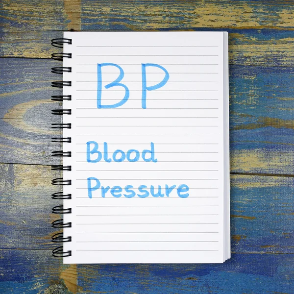 Ciśnienie krwi BP - tekst napisany w notesie na podłoże drewniane — Zdjęcie stockowe