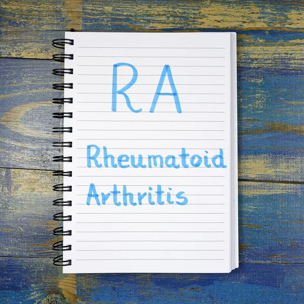 RA- Artrite reumatoide acronimo scritto in notebook su sfondo di legno — Foto Stock