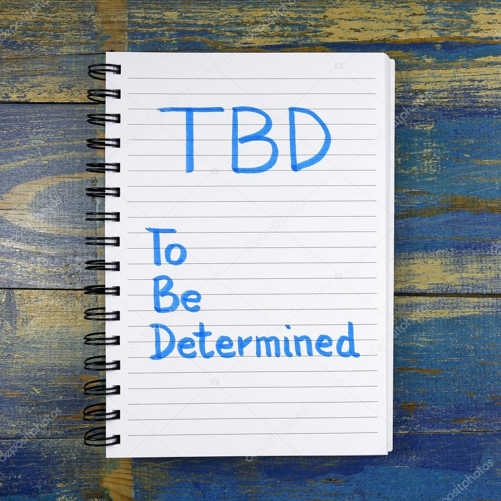 TBD- To Be Determined text written in notebook on wooden background
