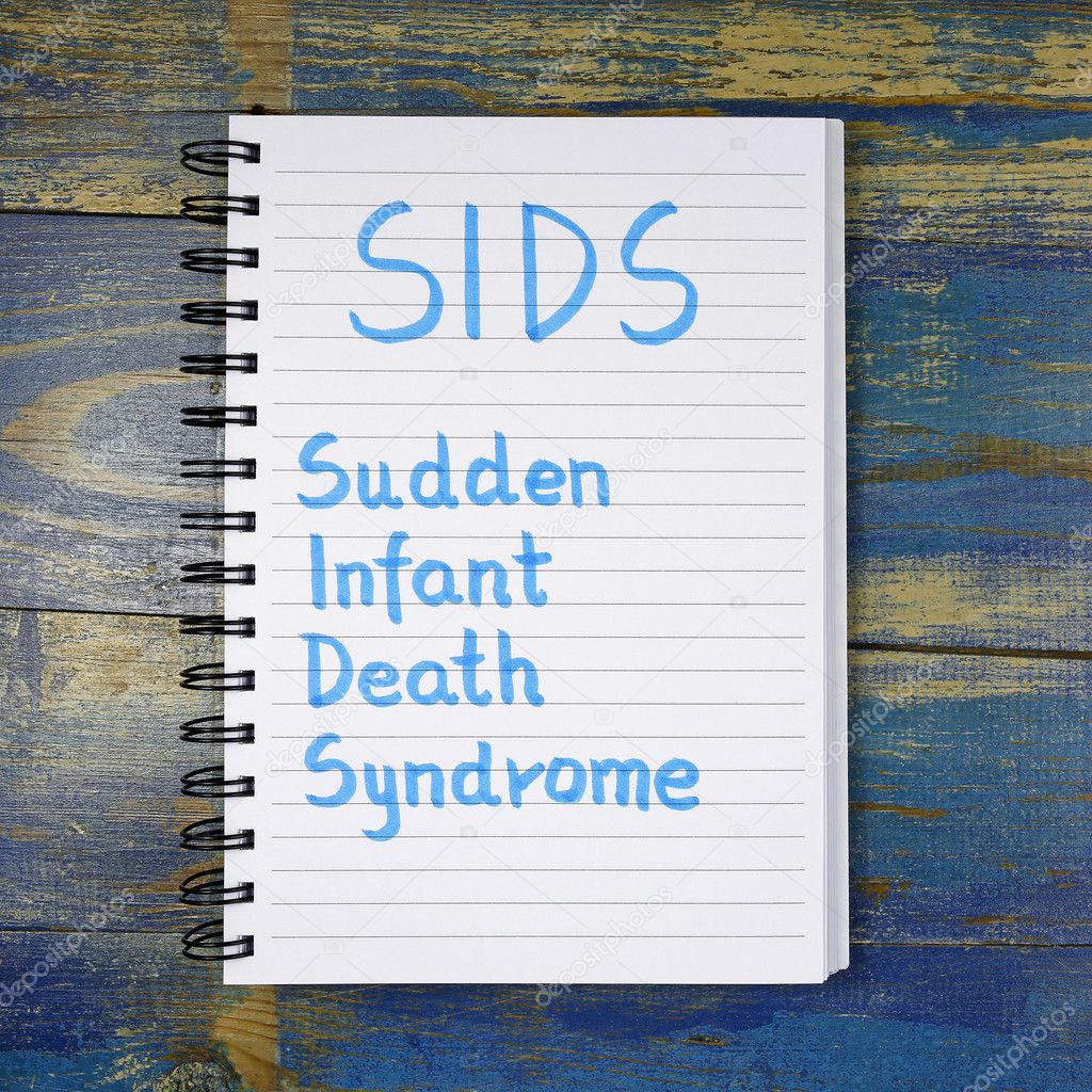 SIDS- Sudden Infant Death Syndrome text written in notebook on wooden background