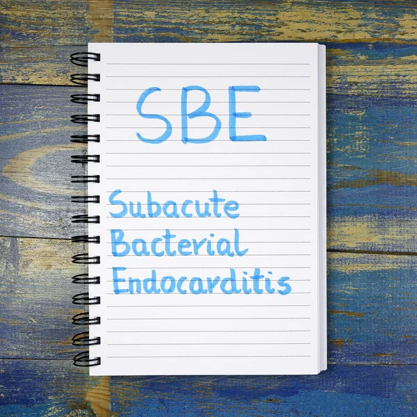 SBE- Subacute Bacterial Endocarditis acronimo scritto in notebook su sfondo di legno — Foto Stock