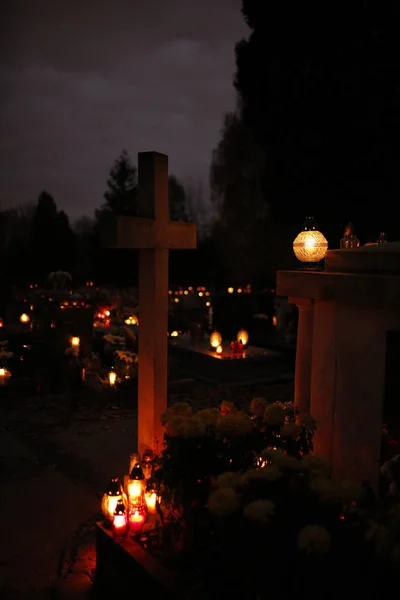 Stenen kruis en kaarsen branden op het kerkhof op Allerheiligen-dag — Stockfoto