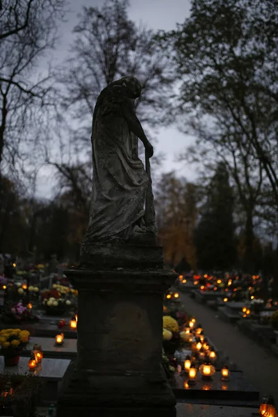 Monumento de piedra y velas encendidas en el cementerio en el Día de Todos los Santos —  Fotos de Stock