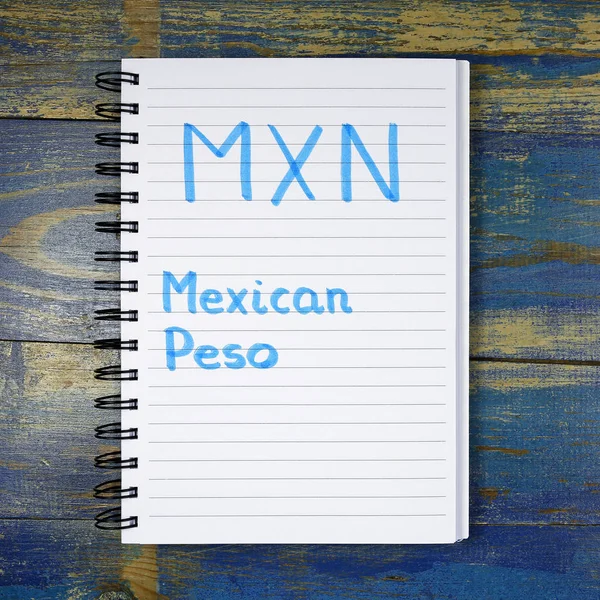 MXN - Мексиканское песо, написанное в блокноте на деревянном фоне — стоковое фото