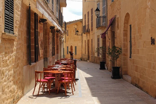 Alcudia, Mallorca, Spanien, 4 April 2016: en av de charmiga gatorna i Alcudia. Det är ett mycket populärt turistmål i Mallorca, känd från mycket väl bevarat karaktären av en historisk stad. — Stockfoto