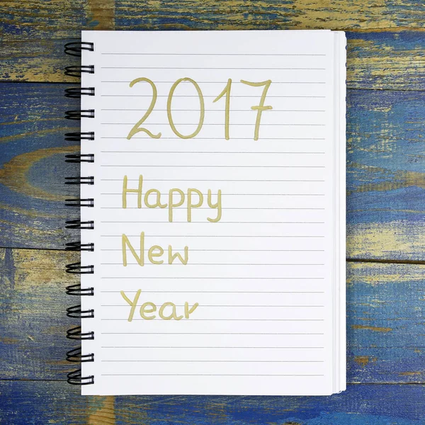 新年あけましておめでとうございます木製の背景にノートに書かれました。 — ストック写真