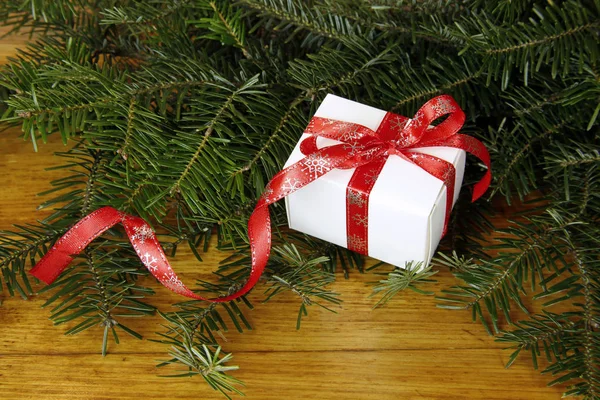 Regalo di Natale con abete su sfondo di legno — Foto Stock