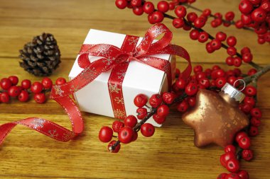 Noel hediyesi yabani gül meyveler, koni ve ahşap arka plan üzerinde biblo