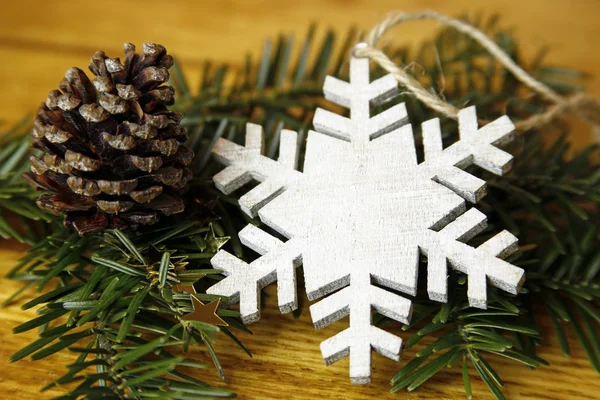 Abete con coni e fiocco di neve su sfondo di legno — Foto Stock