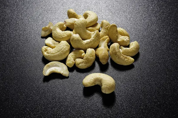 Cashewnötter på svart bakgrund — Stockfoto