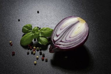 Fesleğenli kırmızı soğan siyah arka plan üzerine bırakır