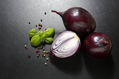 Kırmızı soğan ile fesleğen yaprakları siyah arka plan üzerine