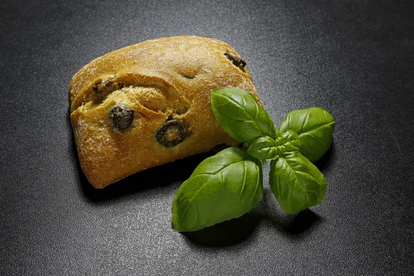 Ciabatta bread with olives and basil leaves — Stock Photo, Image