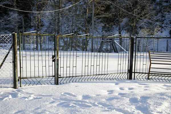 Metalen hek met een poort in de winter — Stockfoto