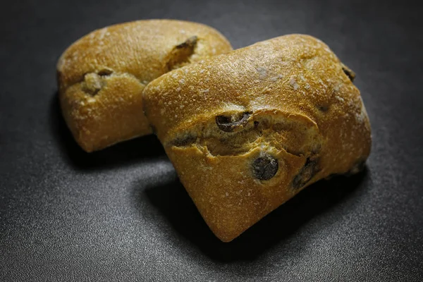 黒の背景に 2 つのオリーブ チャバタのパン — ストック写真