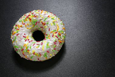 siyah arka plan üzerinde renkli tepesi ile çörek