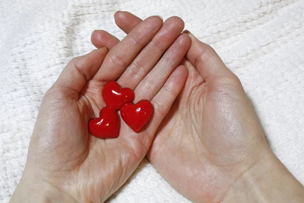 Corazones rojos en manos femeninas — Foto de Stock