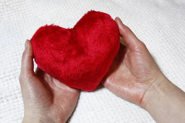 Corazón rojo en manos femeninas — Foto de Stock
