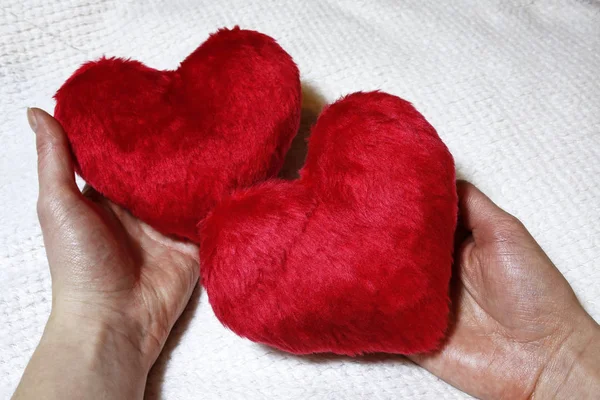 Dos corazones rojos en las manos de las mujeres — Foto de Stock