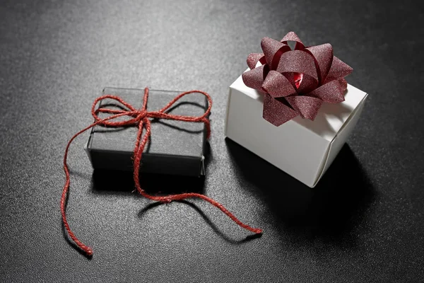 Caixas de presente com fita decorativa no fundo preto — Fotografia de Stock