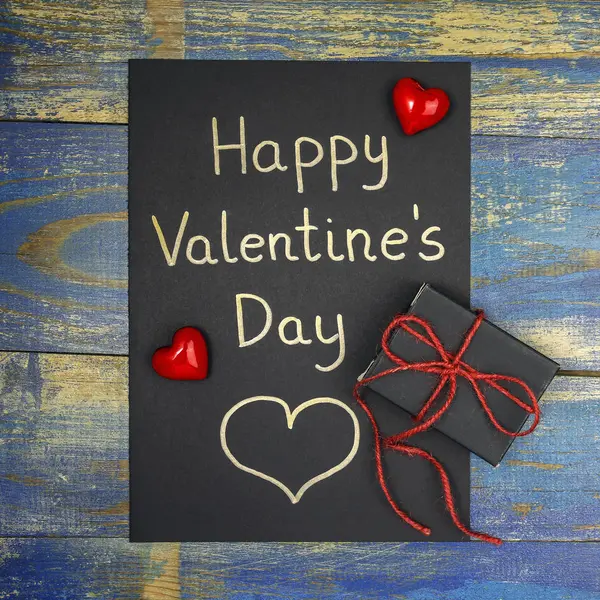 Happy Valentine 's Day card with gift box on wooden background — стоковое фото