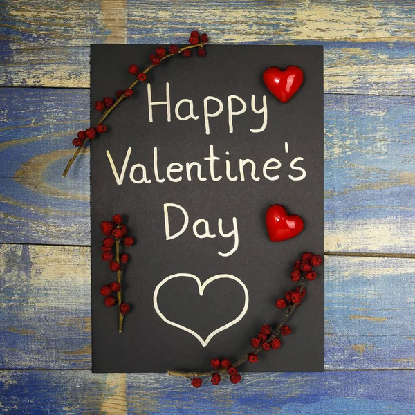 Happy Valentine's Day card decorated with red hearts and wild rose fruits