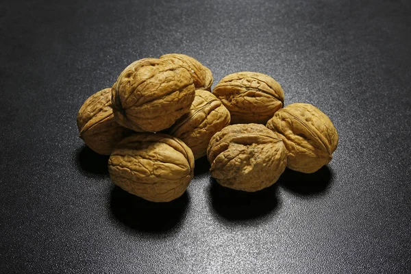Heap of walnuts on black background — Stock Photo, Image