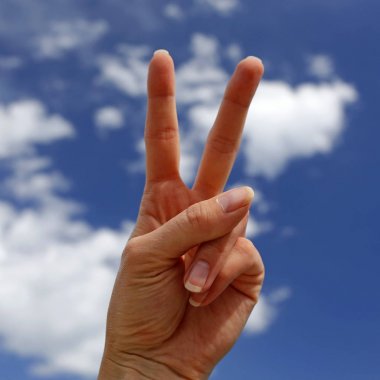 zafer işareti mavi gökyüzü ile arka planda gösterilen el