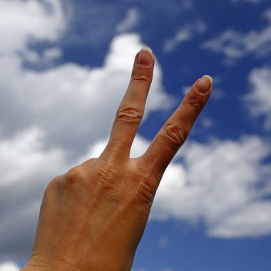 zafer işareti mavi gökyüzü ile arka planda gösterilen el