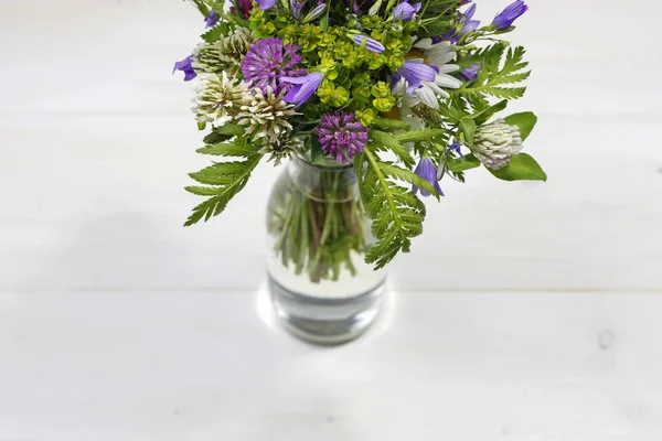 Strauß sommerfrischer Blumen in Glasvase auf weißem Holzhintergrund mit Kopierraum — Stockfoto