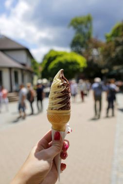 Dondurma koni arka planda bir kadın el ve Turizm tesisi tarafından düzenlenen