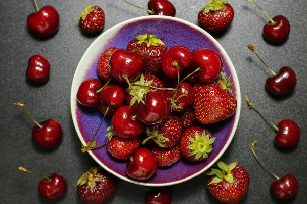 Frutas frescas de verano: fresas y cerezas sobre fondo oscuro —  Fotos de Stock