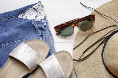 güneş gözlüğü, hasır şapka, kot şort, terlik-yaz aksesuar beyaz ahşap zemin üzerinde
