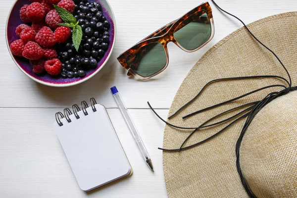 kavram-hasır şapka, meyve, güneş gözlüğü ve defter Beyaz ahşap zemin üzerine rende yaz