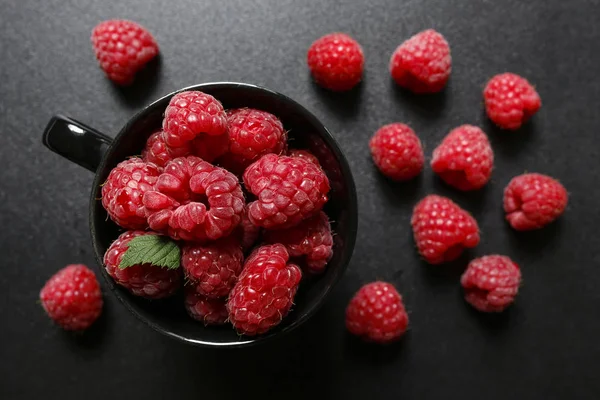 Fresh raspberries in a black cup — Stock Photo, Image