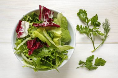 Beyaz arka plan üzerinde bir kapta taze karışık marul yaprakları
