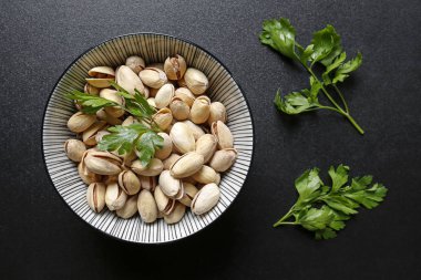 siyah arka plan üzerine bir kase fıstık fındık