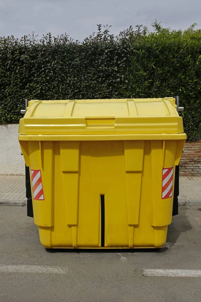 yellow garbage bin on the street