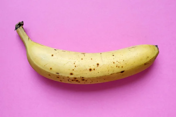 Банан на розовом фоне — стоковое фото