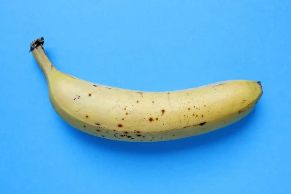 Banan na niebieskim tle — Zdjęcie stockowe