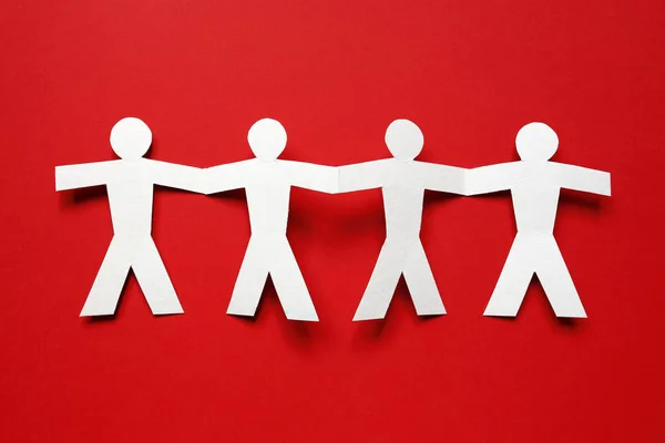 Chain of paper people on red background — Stock Photo, Image