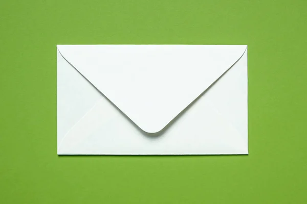 White envelope on green background — Stock Photo, Image
