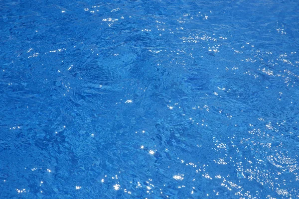 Agua azul en la piscina con reflejos solares —  Fotos de Stock